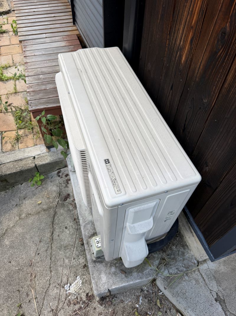 草津市橋岡町の戸建て1階に設置されていた移設前のエアコン室外機